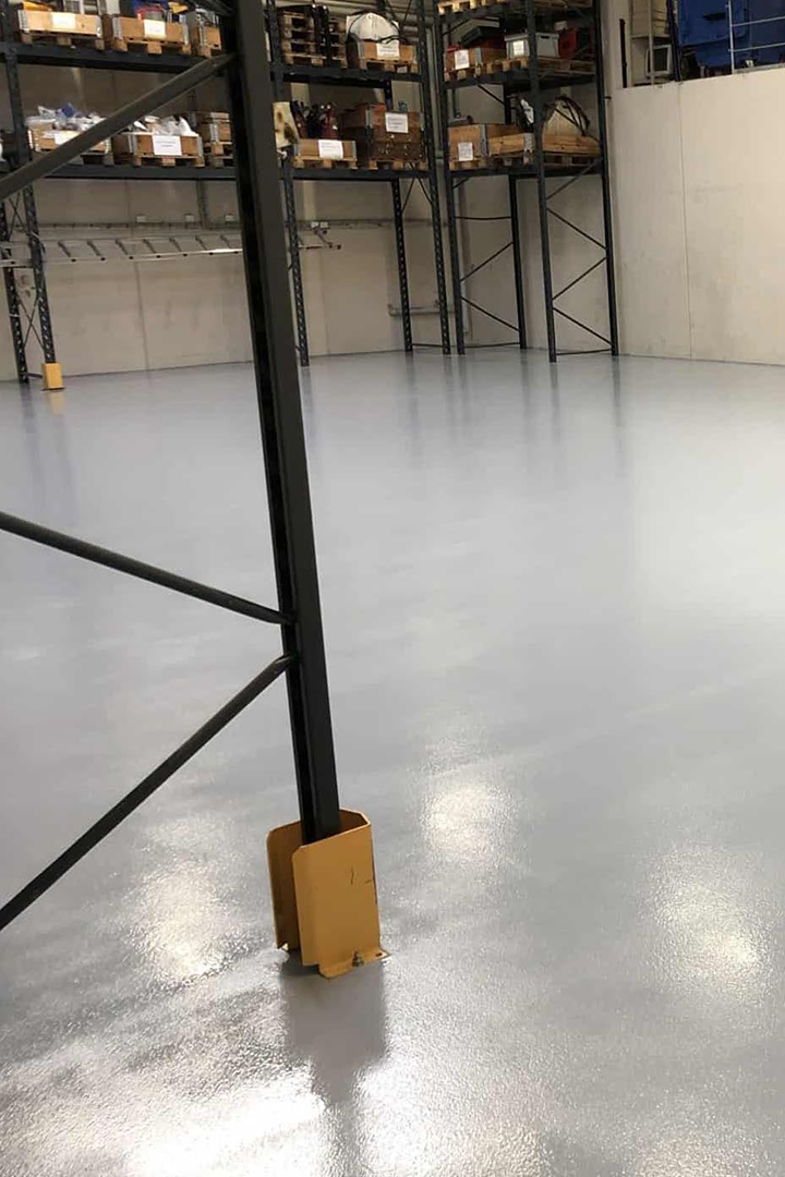 Industrigulv, Fugefri gulve, slidstærke gulve og skridsikre gulve i farven grå i anvendelse på et lager med lagerreoler leveret af ekspert i materialer til gulve Stonewalk