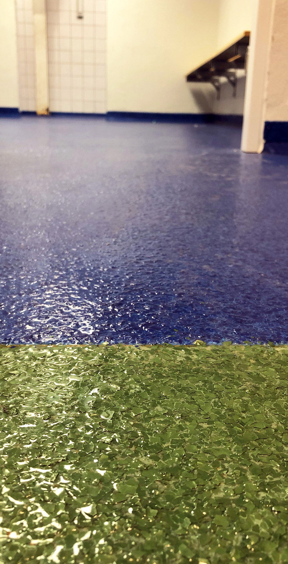 Vådrumsgulv, fugefri gulve og skridsikre gulve i farverne blå og grøn i anvendelse i omklædningsrum hos Engesvang Hallen leveret af ekspert i materialer til gulve Stonewalk